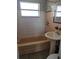 A bathroom featuring a tub, pedestal sink, and white tiled walls at 10106 66Th Ave, Seminole, FL 33772