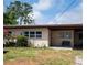 A single story home with a covered carport and front yard with mature landscaping at 10106 66Th Ave, Seminole, FL 33772