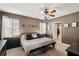Stylish bedroom with a chandelier, dark walls, textured bedding, and a view of an adjacent bathroom at 10230 Geese Trail Cir, Sun City Center, FL 33573