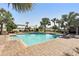 Community swimming pool surrounded by lush palm trees and ample seating for residents at 10230 Geese Trail Cir, Sun City Center, FL 33573