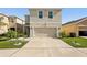 Beige home exterior featuring a spacious driveway and a two-car garage at 10230 Geese Trail Cir, Sun City Center, FL 33573