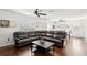 Spacious living room with hardwood floors, fan, and leather sectional at 10230 Geese Trail Cir, Sun City Center, FL 33573
