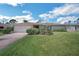 Ranch home with an attached two-car garage, manicured lawn, and lush landscaping at 1137 86Th N Ave, St Petersburg, FL 33702
