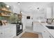 Modern kitchen boasts white cabinets, stylish backsplash, floating shelves, stainless steel appliances, and lots of counter space at 1137 86Th N Ave, St Petersburg, FL 33702