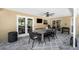 Covered patio featuring stone floors, a dining table set and grill, perfect for outdoor entertaining at 1137 86Th N Ave, St Petersburg, FL 33702