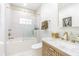 Elegant bathroom with gold fixtures, glass-enclosed tub, and stylish vanity at 1175 Jackson Rd, Clearwater, FL 33755