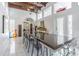Elegant dining room with a long glass table, clear chairs, wood beam ceiling, and a white tile floor at 1175 Jackson Rd, Clearwater, FL 33755