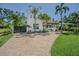 Charming two-story home with lush landscaping, a clay tile roof, and a brick driveway at 1175 Jackson Rd, Clearwater, FL 33755