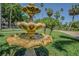 Tranquil water fountain surrounded by green grass and palm trees, creating a serene outdoor atmosphere on a clear day at 1175 Jackson Rd, Clearwater, FL 33755