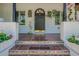 Charming front porch featuring Spanish tile steps with decorative tiles, planters, and a black door with brass trim at 1175 Jackson Rd, Clearwater, FL 33755