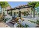Charming front porch with mature landscaping and an ornate black pergola at 1175 Jackson Rd, Clearwater, FL 33755