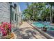 Charming outdoor patio with beautiful flowering plants, leading to a refreshing swimming pool at 1175 Jackson Rd, Clearwater, FL 33755