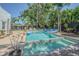 Inviting in-ground pool with clear blue water and lounge seating, surrounded by lush tropical landscaping at 1175 Jackson Rd, Clearwater, FL 33755