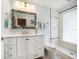 Bright bathroom featuring a single sink vanity with a white countertop, mosaic-style mirror and a walk-in shower at 118 94Th Ave, Treasure Island, FL 33706