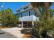 Charming stilt home in a tropical setting featuring a light blue exterior with white trim and ample parking at 118 94Th Ave, Treasure Island, FL 33706