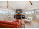 Inviting living room with fireplace, large screen television, and bright windows with natural lighting at 118 94Th Ave, Treasure Island, FL 33706