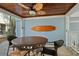 Covered patio featuring a ceiling fan, wooden surfboard decor, and a wicker table with matching chairs at 118 94Th Ave, Treasure Island, FL 33706