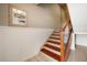 A stairway with hardwood steps, white risers, and a wooden handrail leads to an upper level at 118 94Th Ave, Treasure Island, FL 33706