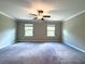 Spacious bedroom with neutral carpeting, a ceiling fan, and large windows offering natural light at 11823 Dumaine Valley Rd, Riverview, FL 33579