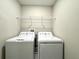 A well-lit laundry area features a washer, dryer, and wire shelving for storage solutions at 11823 Dumaine Valley Rd, Riverview, FL 33579