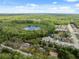 Aerial view of the neighborhood and a lake surrounded by trees at 12430 Oconee Blvd, New Port Richey, FL 34654
