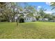 Expansive backyard with lush lawn, mature trees, and a charming single-story home, perfect for outdoor living at 12430 Oconee Blvd, New Port Richey, FL 34654