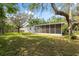Spacious backyard featuring a screened-in porch and a fire pit, ideal for entertaining and relaxing at 12430 Oconee Blvd, New Port Richey, FL 34654