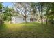Large backyard with lush greenery, mature trees and screened-in porch at 12430 Oconee Blvd, New Port Richey, FL 34654