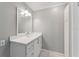 Bathroom featuring a sink with cabinets, large mirror with lighting, and grey walls at 12430 Oconee Blvd, New Port Richey, FL 34654