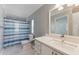 Bathroom featuring a sink with cabinets, commode, and tub with a blue and white striped shower curtain at 12430 Oconee Blvd, New Port Richey, FL 34654