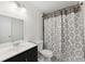 Bathroom featuring a sink with cabinet, commode, tub with shower, and large mirror with lighting at 12430 Oconee Blvd, New Port Richey, FL 34654