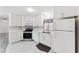 Modern kitchen featuring white cabinets, stainless steel appliances, and stylish tile floor at 12430 Oconee Blvd, New Port Richey, FL 34654