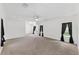 Spacious living room with neutral carpet, white walls, and ceiling fan at 12430 Oconee Blvd, New Port Richey, FL 34654