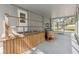 Enclosed patio with stairs to the backyard, wooden railings, a metal shelf, and barrel table at 12430 Oconee Blvd, New Port Richey, FL 34654