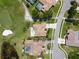 Bird's eye view of a single-story home with a private pool on a golf course, surrounded by mature trees at 1311 Fallsmeade Ct, Oldsmar, FL 34677
