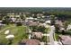 Expansive aerial showing a community surrounding a golf course, showcasing residences with pools and verdant landscaping at 1311 Fallsmeade Ct, Oldsmar, FL 34677