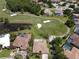 A sprawling aerial view capturing the golf course community, featuring a lush golf course, lakes, and homes with pools at 1311 Fallsmeade Ct, Oldsmar, FL 34677