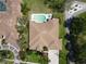 Overhead view of a single-story home with a private swimming pool, lush landscaping, and a tile roof at 1311 Fallsmeade Ct, Oldsmar, FL 34677