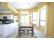 Bright dining room featuring a glass-top table set, adjacent to the kitchen and bathed in natural light from large windows at 1311 Fallsmeade Ct, Oldsmar, FL 34677