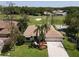 Golf course home showcasing lush landscaping and mature trees surrounding a paver driveway and neutral exterior at 1311 Fallsmeade Ct, Oldsmar, FL 34677