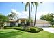 Charming home with lush landscaping, a well-manicured lawn, and a three-car garage at 1311 Fallsmeade Ct, Oldsmar, FL 34677