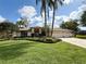 Charming home with lush landscaping, a well-manicured lawn, and a welcoming double-door entrance at 1311 Fallsmeade Ct, Oldsmar, FL 34677