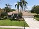 Beautiful single-story home featuring a well-manicured lawn, lovely landscaping, and a three-car garage at 1311 Fallsmeade Ct, Oldsmar, FL 34677