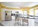 Bright kitchen features marble floors, white cabinetry, stainless appliances, and a black granite breakfast bar at 1311 Fallsmeade Ct, Oldsmar, FL 34677