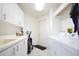 Bright laundry room with ample storage, modern appliances, and convenient workspace at 1311 Fallsmeade Ct, Oldsmar, FL 34677