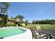 Poolside dining set in a lush backyard, offering a scenic view of the golf course, perfect for relaxation at 1311 Fallsmeade Ct, Oldsmar, FL 34677