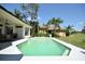 This backyard features a sparkling pool with lush landscaping and a view of the golf course, perfect for outdoor living at 1311 Fallsmeade Ct, Oldsmar, FL 34677