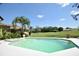 The backyard features a sparkling pool with a lush green golf course view, perfect for relaxation and enjoyment at 1311 Fallsmeade Ct, Oldsmar, FL 34677