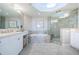 Well-lit bathroom with dual vanity sinks, a soaking tub, and a glass-enclosed shower at 1325 Snell Isle Ne Blvd # 607, St Petersburg, FL 33704