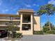 Exterior shot of multi-level building with balconies, a tree, and partial driveway at 1370 Heather Ridge Blvd # 310, Dunedin, FL 34698